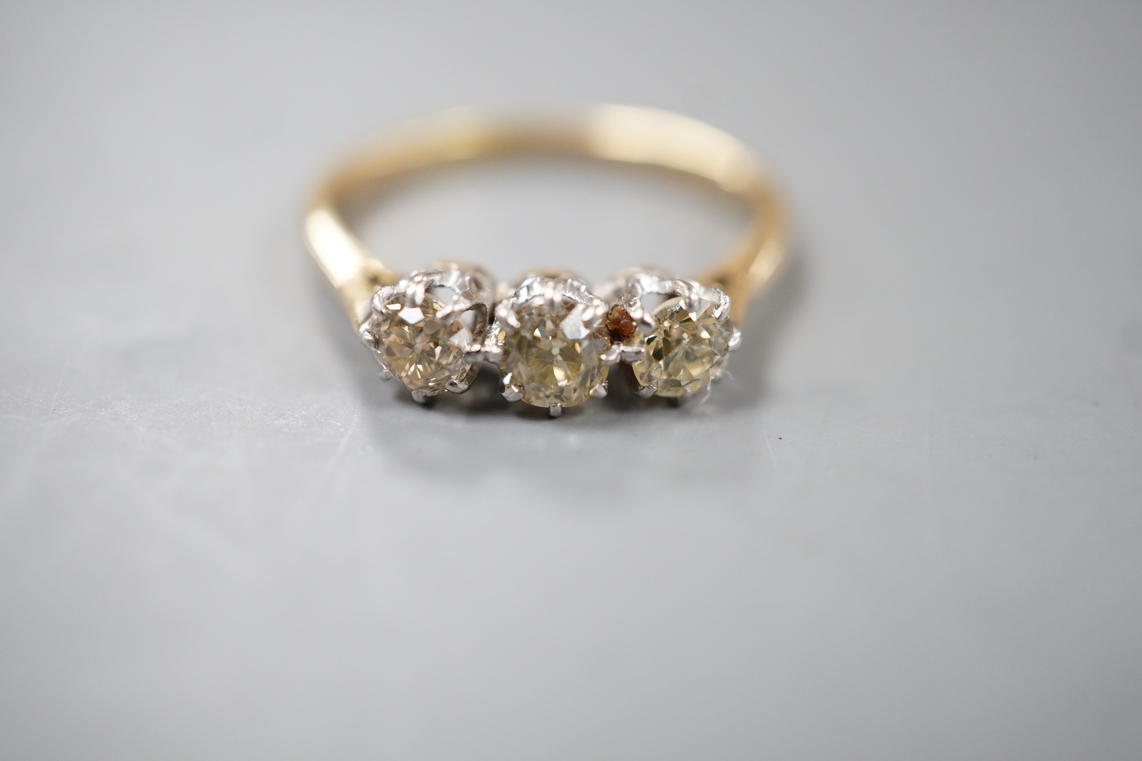 An 18ct and three stone diamond set ring, size P, gross weight 2.8 grams.